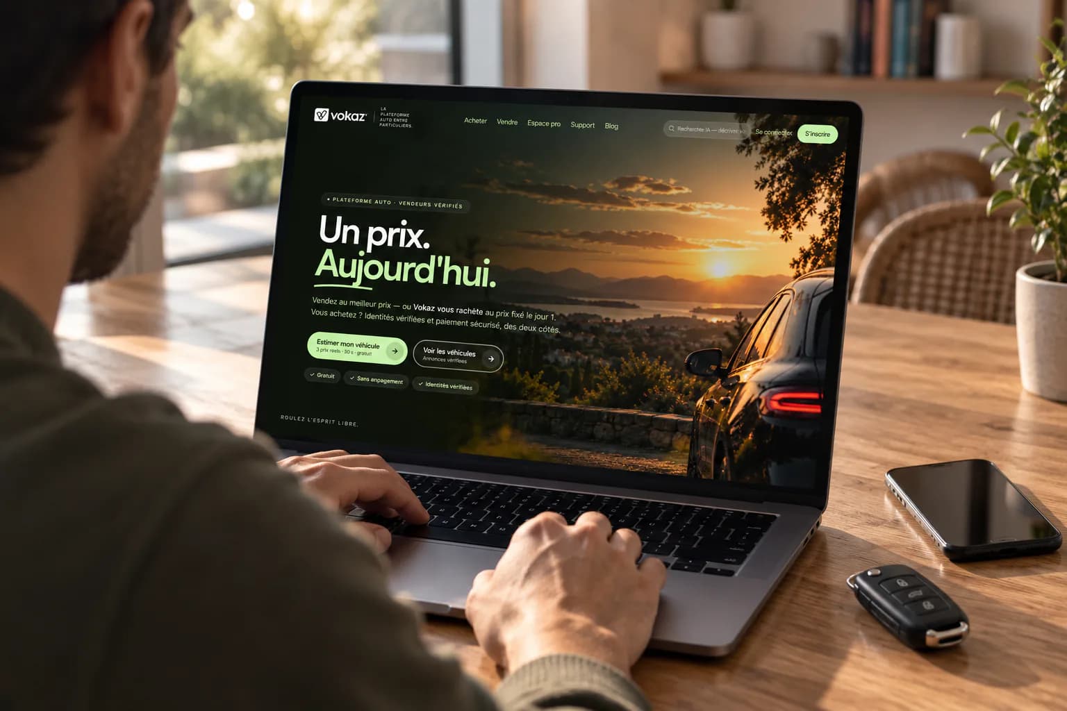 Un vendeur publie lui-même son annonce depuis l'accueil Vokaz sur son ordinateur portable, ses clés posées sur la table.